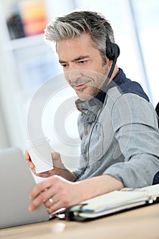 Mature man teleworking and drinking coffee photo