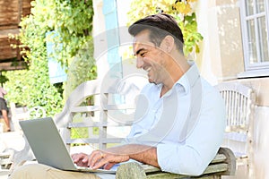 Mature man teleworking on terrace