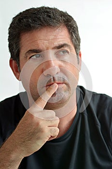 Mature man thinking with one finger on his lips