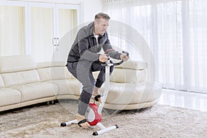 Mature man training with a spin bike at home