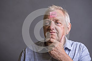 Mature man with an urgent note on his forehead