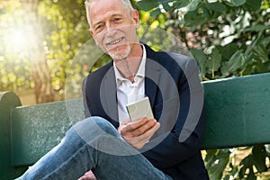 Mature man using his mobile phone, light effect