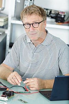 Mature man using laptop cables