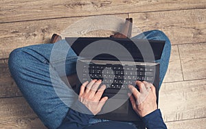 Mature  man using laptop computer. Male hands typing on laptop keyboard. Business working, freelance or remote work concept.