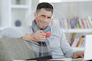 mature man using laptop on desk at home