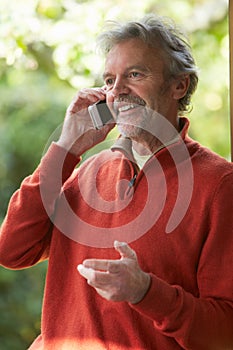 Mature Man Using Mobile Phone At Home