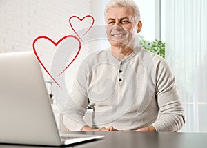 Mature man visiting dating site via laptop