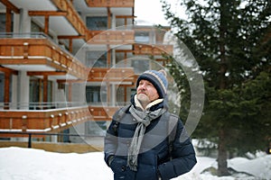 Mature man walking on street of mountain resort town in Switzerland, Europe. Winter vacation