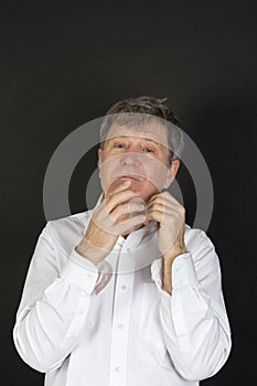 Mature man in white business shirt looking snotty