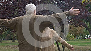 Mature man and woman hugging outdoors, family meeting, relatives closeness