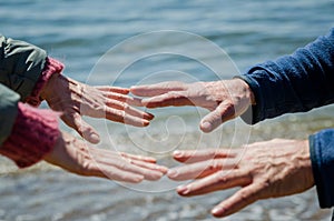 Mature man and woman reaching hands to each other