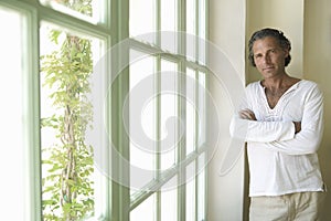 Mature man by wooden window.