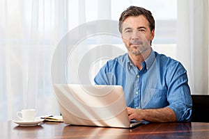 Mature man working at home in the kitchen