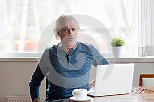 Mature man working on pc feels sudden back pain