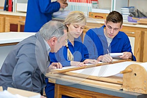 mature man in workshop with apprentices
