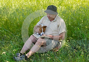 Mature man and young dog reading interesting book