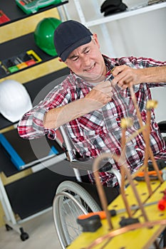 Mature manual worker in wheelchair