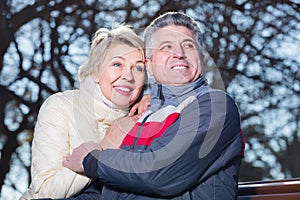 Mature married couple sitting on park bench