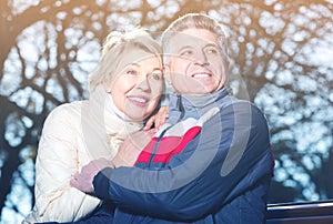 Mature married couple sitting on park bench