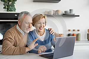 Mature married family couple making video call on laptop