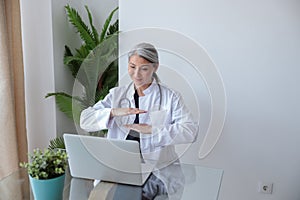 Mature medical specialist communicating via video link