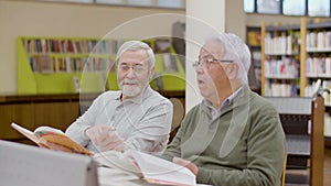 Mature men talking while having lesson in library