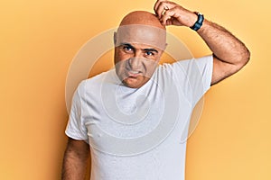 Mature middle east man wearing casual white tshirt confuse and wonder about question