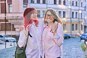 Mature mom hugging her teenage daughter, outdoor