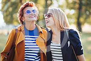 Mature mother and adult daughter enjoying a day in the park