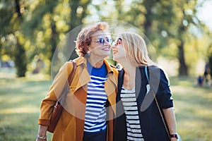 Mature mother and adult daughter enjoying a day in the park