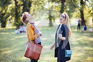 Mature mother and adult daughter enjoying in the park