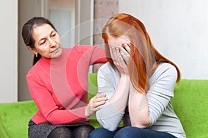 Mature mother comforts crying daughter