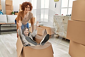 Mature mother and down syndrome daughter moving to a new home, having fun inside box