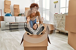 Mature mother and down syndrome daughter moving to a new home, having fun inside box