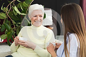 Mature mother and her daughter relaxing on sofa