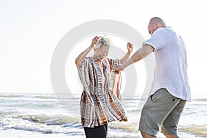 Mature mother and son dancing on the beach photo