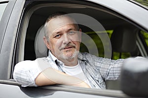 Mature Motorist Looking Out Of Car Window