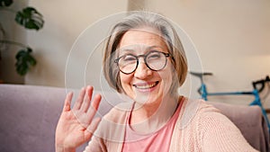 Mature old 60s woman, older middle aged female customer making video call meeting looking at camera smiling while
