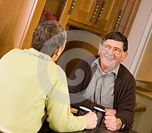 Mature older couple laughing together in kitchen