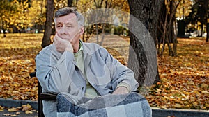 Mature outdoors upset senior retired caucasian man grandfather pensioner sitting alone in wheelchair depressed pensive