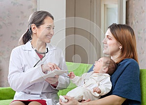 Mature pediatrician of prescribes to newborn baby the medicatio photo