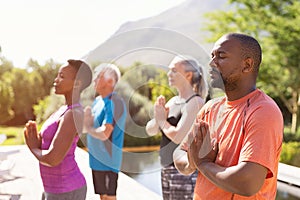 Mature people meditating together at park