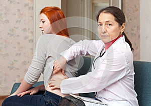 Mature physician touching behind of patient