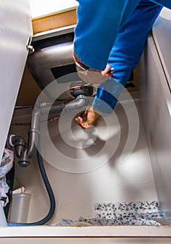 Mature plumber install sink in the kitchen