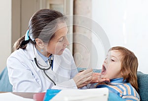 Mature practitioner looks mouth of baby