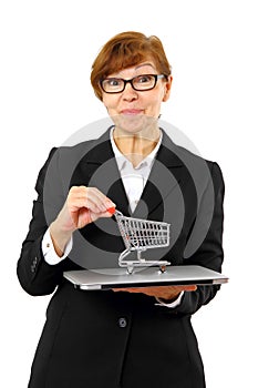 Mature red haired business woman with shopping cart, laptop