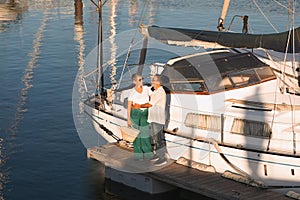 Mature Sailboat Owners Couple Posing Near Yacht At Dock Outdoors