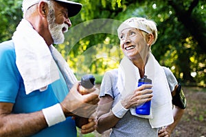 Mature or senior couple doing sport outdoors, jogging in a park