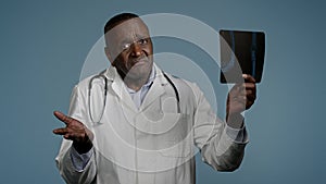 Mature serious man radiologist doctor examining x-ray check results scan looking pensive and focused upset male medic