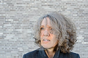 Mature serious woman with curly tousled hair